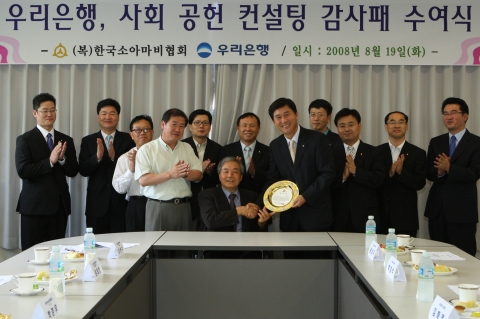 우리은행은 사회복지법인 한국소아마비협회 소속으로 장애인의 재활을 돕는 사회적 기업인 정립전자에 대해 매출 향상 및 원가 절감을 통한 기업 수익성 제고를 위해 경영컨설팅 서비스를 제공했다. 이에  대한 감사의 표시로 19일 한국소아마비협회 이완주 이사장(사진 중심으로 좌측)이 우리은행 윤상구 부행장(사진 중심으로 우측)에게 감사패를 전달한 후 기념촬영을 하고 있다.