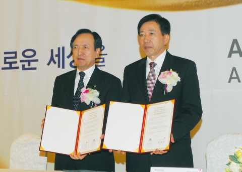 아시아나항공 강주안사장(좌측)이 25일 소공동 웨스틴조선호텔에서 열린 아시아나클럽 제휴사 조인식에서 제휴사 대표인 현대자동차 문용호 상무와 함께 제휴 약정서를 펼쳐 보이고 있다.