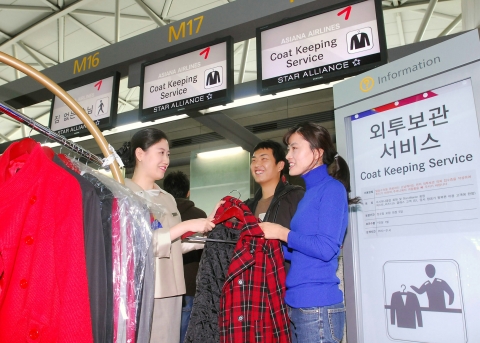 인천공항 여객터미널 3층 아시아나항공 K아일랜드 전면 카운터에서 탑승객이 아시아나항공 직원에게 외투보관 서비스를 신청하고 있다.
