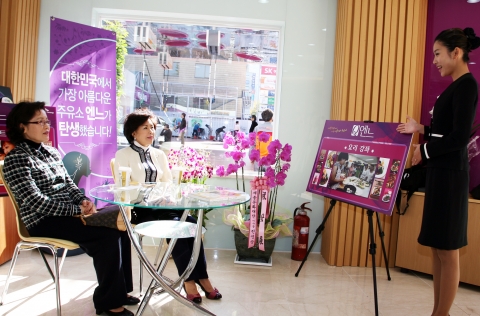 여성친화주유소인 SK ‘엔느’주유소 내부 고객 쉼터에서 고객 두 명이 커피를 마시며 요리 강좌에 대해 듣고 있다.