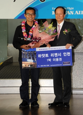 미국비자 면제프로그램(VWP) 시행 첫날인 17일 오전 인천국제공항에서 이종희 대한항공 총괄사장이 비자면제 첫 출국 승객인 한윤민(왼쪽)씨에게 꽃다발과 특급호텔 (하얏트 리젠시 인