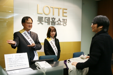 롯데홈쇼핑 이흥영 CS혁신팀장이 “협력업체 여러분 사랑합니다” 띠를 두르고 본사 상담실을 찾은 협력사 직원을 맞이하고 있다.