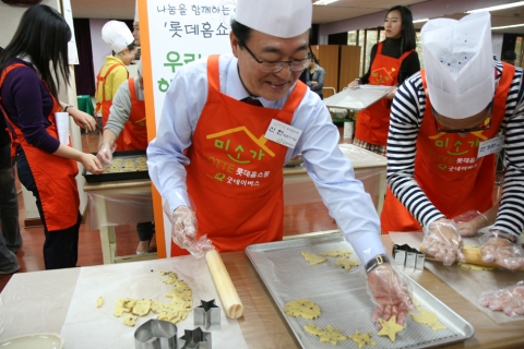 롯데홈쇼핑 신헌 대표가 직원과 함께 저소득가정에 배달할 쿠키를 만들고 있다.