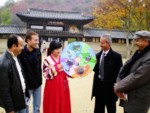 경기도 용인 한국민속촌을 찾은 외국 관광객들이 경기도 주요 영상 촬영지와 전통 문화체험지를 담은 ‘경기 콘텐츠 도넛’을 살펴보고 있다.