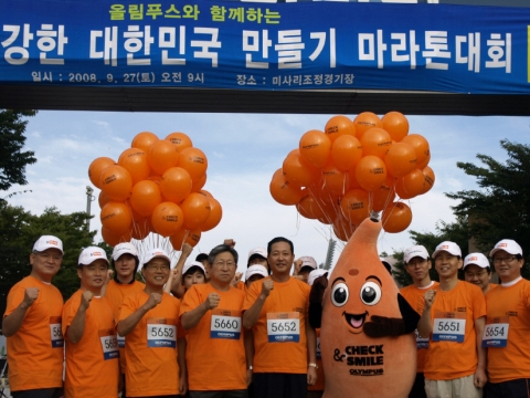 지난 27일 미사리조정경기장에서 열린 &#039;올림푸스와 함께하는 제5회 건강한 대한민국 만들기 마라톤대회&#039;에서 올림푸스한국 방일석 대표(앞줄 왼쪽에서 다섯번째)와 대한소화기내시경학회 함준수 이사장(앞줄 왼쪽에서 네번째)이 마라톤 대회에 참가한 올림푸스한국 임직원과 함께 위암∙대장암 예방 캠페인 ‘CHECK&SMILE(체크앤스마일)’의 실천을 다짐하고 있다.