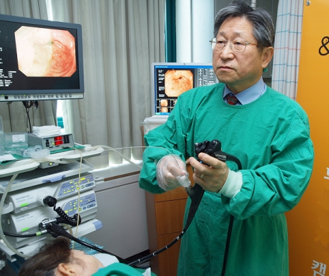 올림푸스한국이 대한소화기내시경학회와 함께 지난 8일 서울지역 6개 병원에서 실시한 무료 검진 이벤트에서 한 수혜자가 대한소화기내시경학회 함준수 이사장으로부터 무료 검진을 받고 있다.