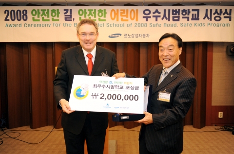 르노삼성자동차 장 마리 위르띠제 사장이 <2008 안전한 길, 안전한 어린이 우수시범학교 시상식>에서 최우수 시범학교로 선정된 대구 동부초등학교 김광호 교장에게 상금을 
