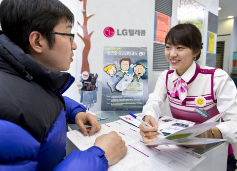 LG텔레콤 대리점을 방문한 고객이 저소득층을 위한 휴대전화 요금감면제도에 대해 설명을 듣고 있는 모습.