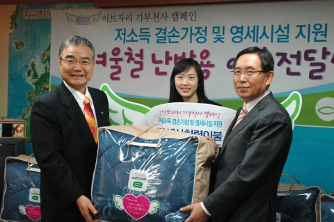이브자리 고춘홍 대표와 소비자 대표 김지나씨가 기아대책 정정섭 회장에게 사랑의 이불을 전달하고 있다.