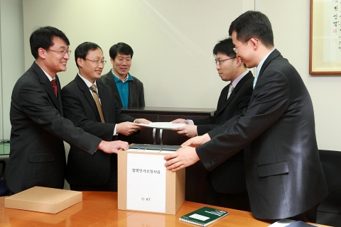 KT 직원들이(신청서 왼쪽) 방통위에 KT-KTF 합병인가신청서를 제출하고 있다(종로구 세종로 방송통신위원회 사무실)