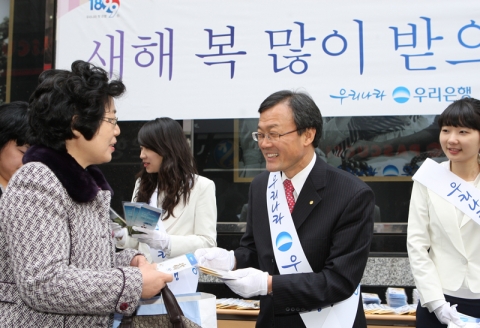 21일 이순우 우리은행 수석부행장을 포함한 직원 30여명이 설날을 맞이해 한해동안 고객들의 성원에 감사코자 우리은행 명동지점 앞에서 지나가는 고객들에게 소띠 해를 맞아 행복을 전하