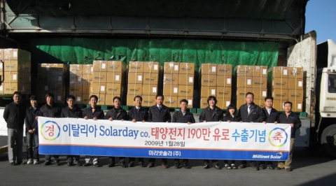 미리넷솔라 대구 공장 임직원들이 이태리로 첫 대규모 출하자축 플래카드를 들고 밝게 웃고 있다.