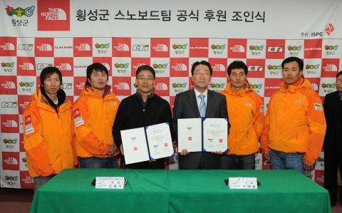 횡성군수 한규호와 (주)골드윈코리아의 김형호 차장이 조인서에 서명 후 선수들과 기념촬영에 임하고 있다.