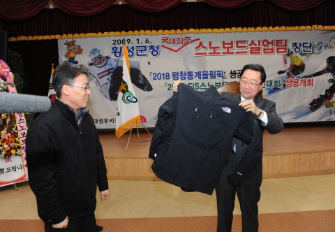(주)골드윈코리아의 김형우 차장이 횡성군수한테 단복을 증정하고 있다.
