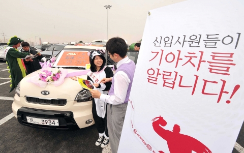 신입사원들이 휴게소에서 고객들에게 기아자동차를 소개하고 있는 모습.