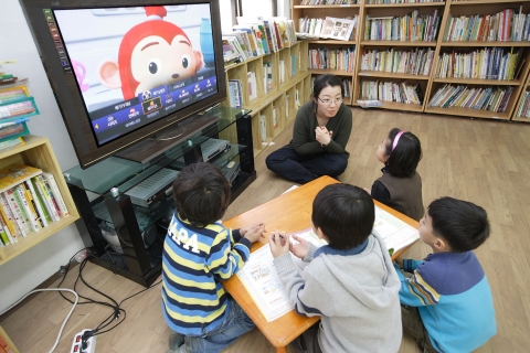 광진구에 위치한 KT공부방 ‘새날아동센터’의 아이들이 선생님과 함께 메가TV를 통해 공부를 하고 있다.