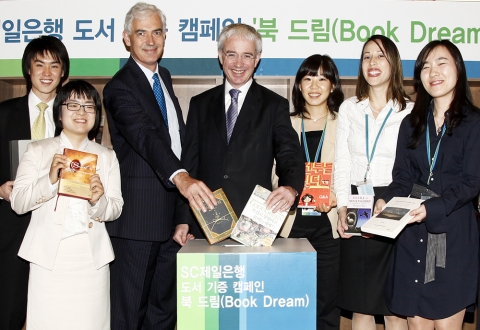 SC제일은행 직원들과 책을 기증하는 피터 샌즈 스탠다드차타드 그룹 CEO(우측)과 데이비드 에드워즈 SC제일은행장(좌측)