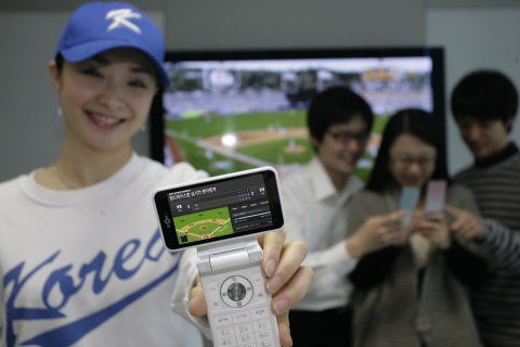 LG텔레콤 고객이 OZ전용 단말기를 이용해 한국과 일본의 WBC 결승전 경기현황을 실시간으로 확인하고 있는 모습.