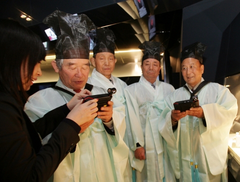 SK텔레콤은 체험관 T.um에서 25일 성균관 유림을 초청해 이동전화의 과거와 현재,미래를 보여주는 행사를 진행했다.  성균관 유생들이 미래형 휴대폰 T-Key에 대한 설명을 듣고
