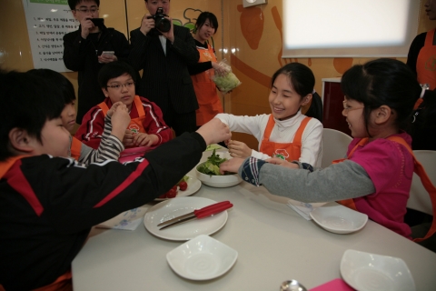 한국청소년단체협의회와 생명보험사회공헌위원회가 공동으로 개최한 &#039;찾아가는 쿠킹버스 출범식&#039;에서 참가 어린이 청소년들이 쿠킹버스 안에서 직접 요리를 만들고 있다.