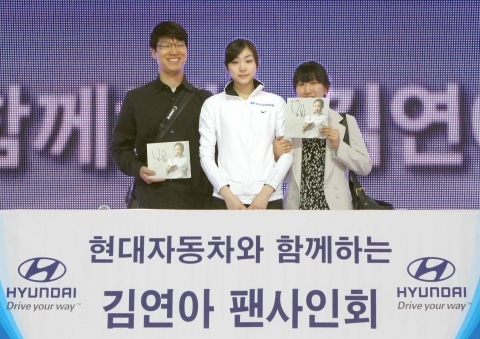 김연아 선수가 이 날 팬사인회의 첫번째 주인공들과 함께 기념 촬영을 하고 있는 모습(좌측부터 조성운 씨, 김연아 선수, 최의경 씨)