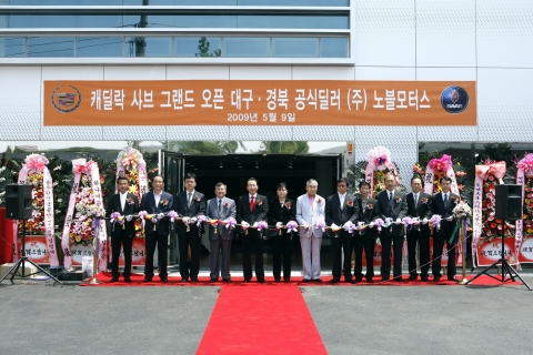 GM 코리아의 캐딜락-사브 대구 전시장 오픈을 기념하며 GM 코리아의 김성기 대표 (사진 왼쪽 4번째)와 노블 모터스의 유귀남 대표이사 (사진 왼쪽 5번째)가 기념 커팅을 하고 있