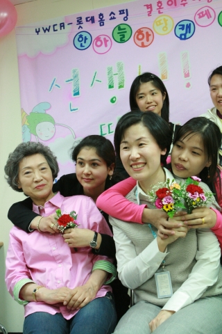 결혼이민여성들이 선생님께 감사의 카네이션을 달아드리는 모습