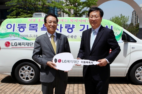 남상건 LG복지재단 부사장(왼쪽)이 조윤길 옹진군수에게 이동목욕차량 자동차 키 모형을 전달하고 있는 모습.