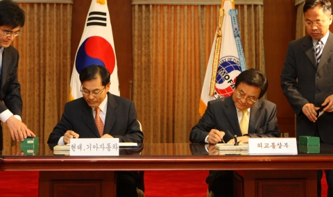 임재홍 외교통상부 기획조정실장(사진 우측)과 양승석 현대자동차 사장(사진 좌측)이 양해각서 체결을 위해 서명을 하고 있는 모습.