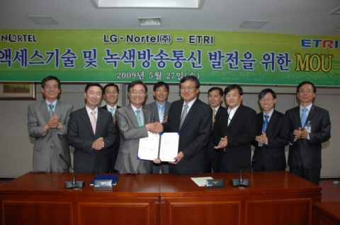 LG-Nortel 이재령 사장(사진에서 중간부분 왼쪽)과 ETRI 최문기 원장(사진에서 중간부분 오른쪽)이 MOU 체결 후 양 기관의 발전을 위해 악수하고 있는 모습