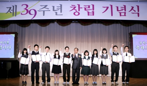 창립 39주년 기념식을 맞아 경남은행 문동성 은행장(왼쪽 여섯번째, 중앙)이 지역의 성적우수 장학생들에게 ‘경은장학회 장학증서’를 수여하고 파이팅을 외치고 있다.