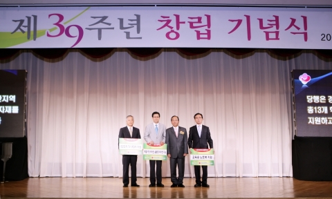 창립 39주년 기념식을 맞아 경남은행 문동성 은행장(오른쪽 두번째)이 지역 고등학교 교장·교감선생님에게 ‘학습기자재 기증서’를 전달하고 기념촬영하고 있다.