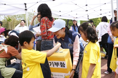 5월 5일 어린이 날, 서울 올림픽공원 평화의 광장에서 신한금융그룹이 개최한 어린이 벼룩시장 ‘병아리떼 쫑쫑쫑’에서 행사에 참가한 어린이가 물품 판매 수익금을 기부하고 있다.