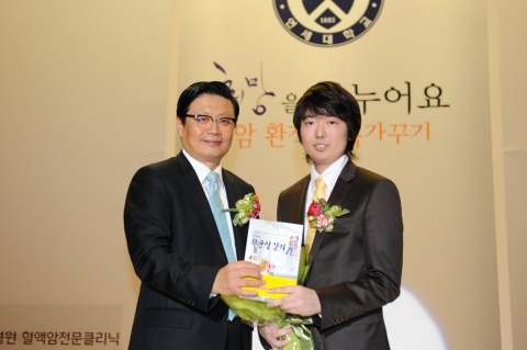 이상우 씨(오른쪽)가 민유홍 교수에게 자신의 책을 전달하고 있다.