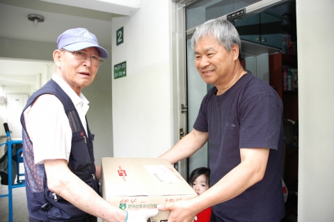 아파트택배 배송을 하시는 김종철(77) 할아버지가 고객에게 택배물건을 전달하고 있다.