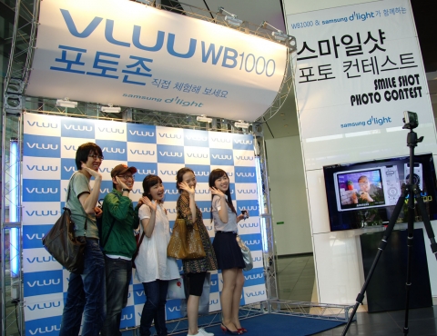 삼성전자 서초사옥에 위치한 홍보관에서 삼성디지털이미징이 새롭게 출시한 카메라 WB1000을 통해 내방객들이 렌즈를 보고 웃기만 하면 자동으로 사진이 찍히는 스마일 샷 기능을 체험하