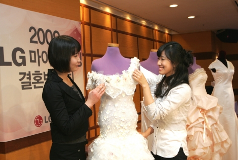 지난 ‘LG마이e웨딩 결혼박람회’에서 예비신부가 웨딩드레스를 보며 참가업체의 설명을 듣고 있는 모습.