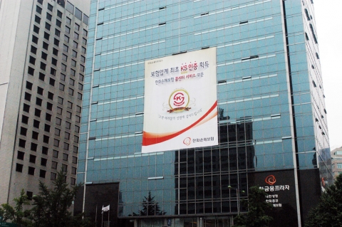 한화손해보험은 이번 콜센터 서비스 부문 KS 인증을 기념하기 위해 전국의 각 사업장 건물 외부에 대형 현수막을 설치했다. 서울 태평로 한화손해보험 본사 건물에 KS 인증을 기념하는 대형 현수막이 설치되어 있다.
