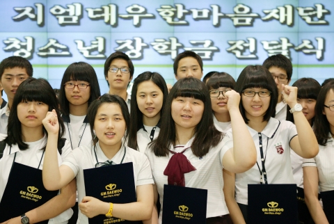 장학금을 받은 학생들이 GM DAEWOO 홍보관에서 파이팅을 외치고 있는 장면.