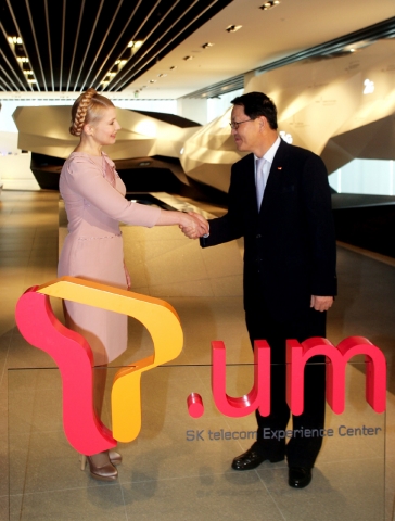 T.um을 둘러본 율리아 티모셴코 총리와 정만원 사장이 악수하고 있다.