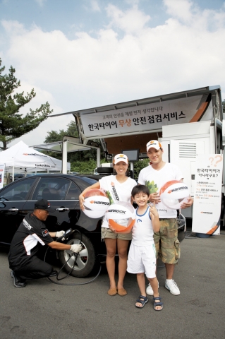 한국타이어 점검 요원이 한국타이어 무상 안전점검 서비스 행사장에서 고객의 타이어를 점검하고 있다.