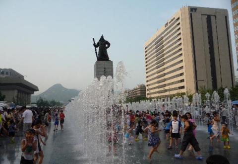 광화문광장 이순신동상 주변 12.23분수에서 형형색색으로 뿜어 오르는 물줄기를 맞으며 시민들이 즐거워하고 있다