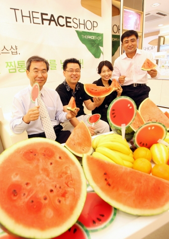 장절준 부사장(왼쪽)이 수박과 수박부채를 들고 직원들과 즐거운 시간을 갖고 있다.