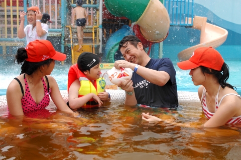 SK C&C 공공사업 2담당 이종은 부장(사진 오른쪽 2번째)과 가족들이 지체장애아동과 함께 물놀이를 하고 있는 모습