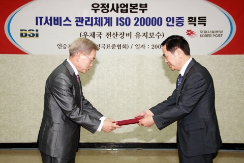 서광현 우정사업정보센터장(오른쪽)이 8일 BSI코리아 천정기 대표로부터 IT서비스 관리체계 ISO 20000 인증서를 받고 있다. <사진제공 : 우정사업본부>