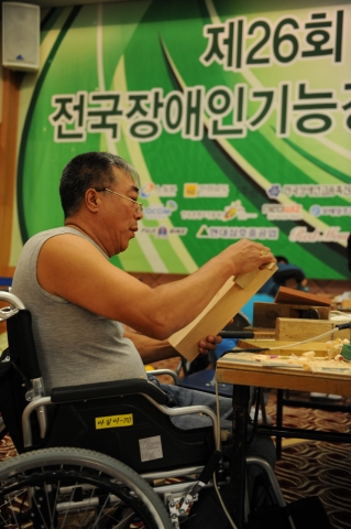 “장인의 손길이 깃든 가구” 제 26회 한국장애인기능경기대회 정규종목 가구제작에 참가한 선수가 노련한 손길로 가구를 다듬고 있다.