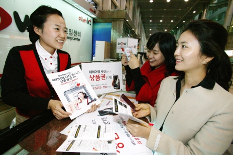 서울 삼성동 도심공항 쇼 글로벌 로밍센터에서 고객이 로밍 서비스 이용 방법과 사진 콘테스트 참여 방법에 대해 안내 받고 있다.