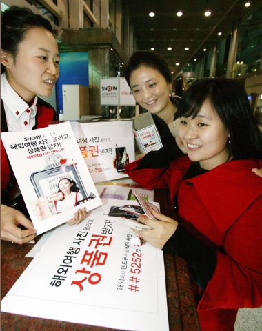 서울 삼성동 도심공항 쇼 글로벌 로밍센터에서 고객이 로밍 서비스 이용 방법과 사진 콘테스트 참여 방법에 대해 안내 받고 있다.