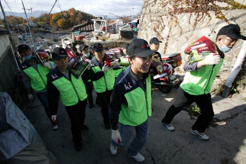 KT 개인고객부문 김우식사장과 임직원 70여명이 중계본동의 여려운 이웃들에게 쌀과 연탄을 나눠주고있다