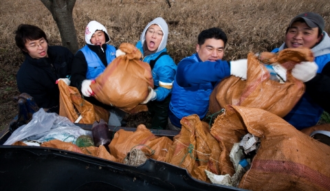 국립중앙청소년수련원 전 직원들이 산방천 환경정비 봉사활동을 하며 나온 쓰레기 더미를 차량에 싣고 있다.